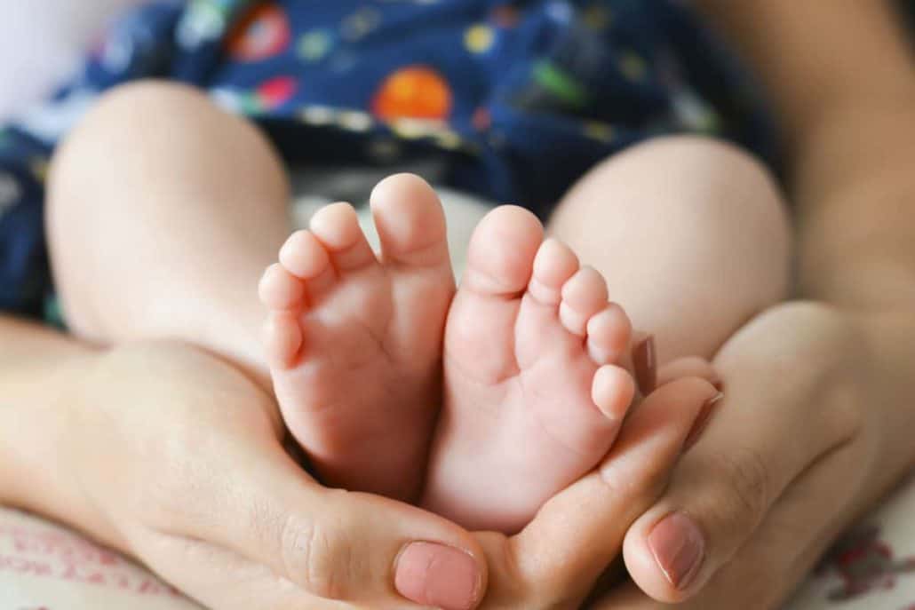 baby's feet in mothers hands
